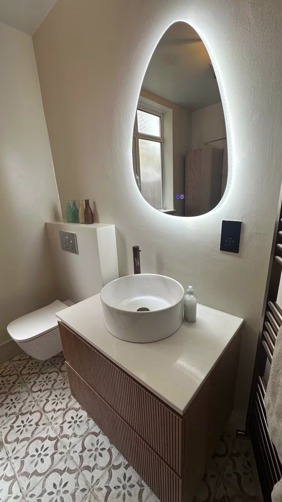 Renovated bathroom with feature mirror and patterned floor tiles